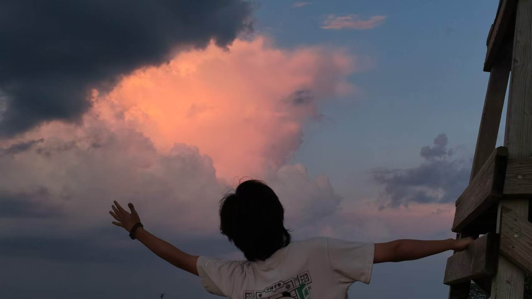 Zicong standing beneath a dramatic evening sky